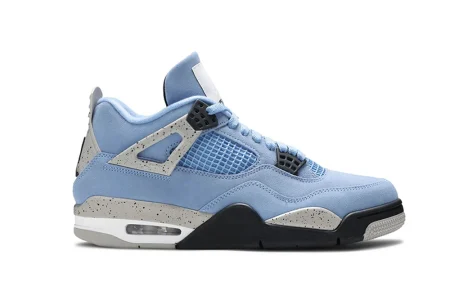 A front view of the outer side of the right shoe of the Jordan 4 Retro ‘University Blue,’ showcasing its overall silhouette and blue suede upper material.