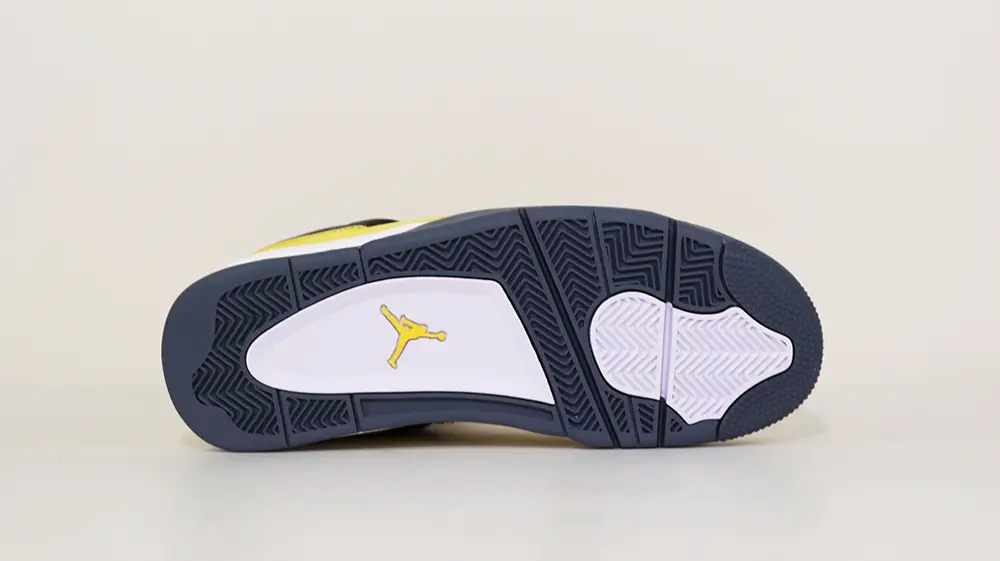 A bottom view of the Jordan 4 Retro ‘Lightning’ (2021), showcasing its black and white rubber outsole