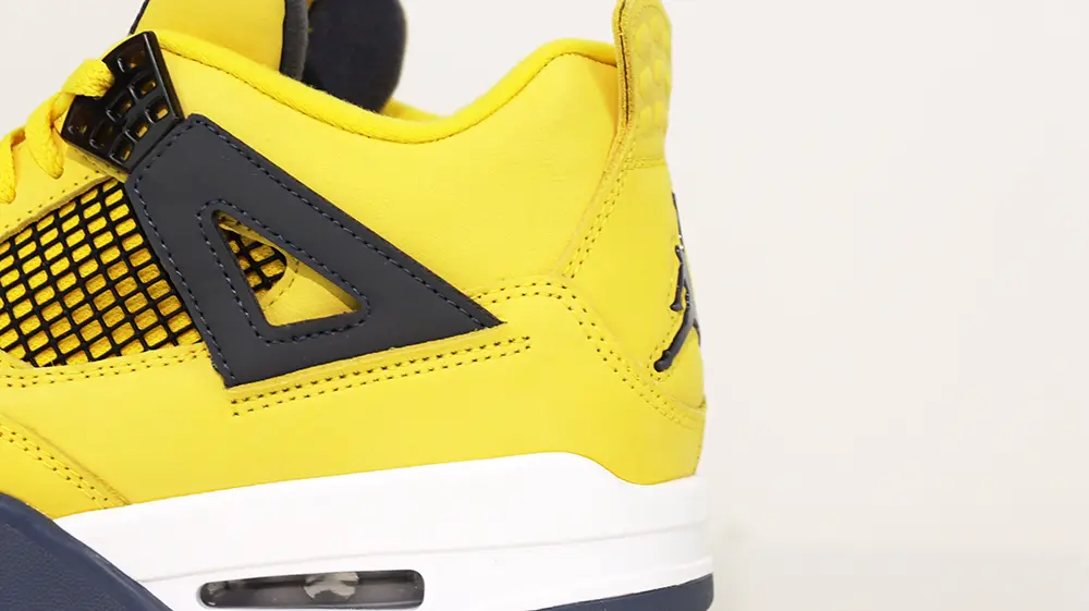 A rear view of the heel on the Jordan 4 Retro ‘Lightning’ (2021), featuring yellow suede material and a black Jumpman logo