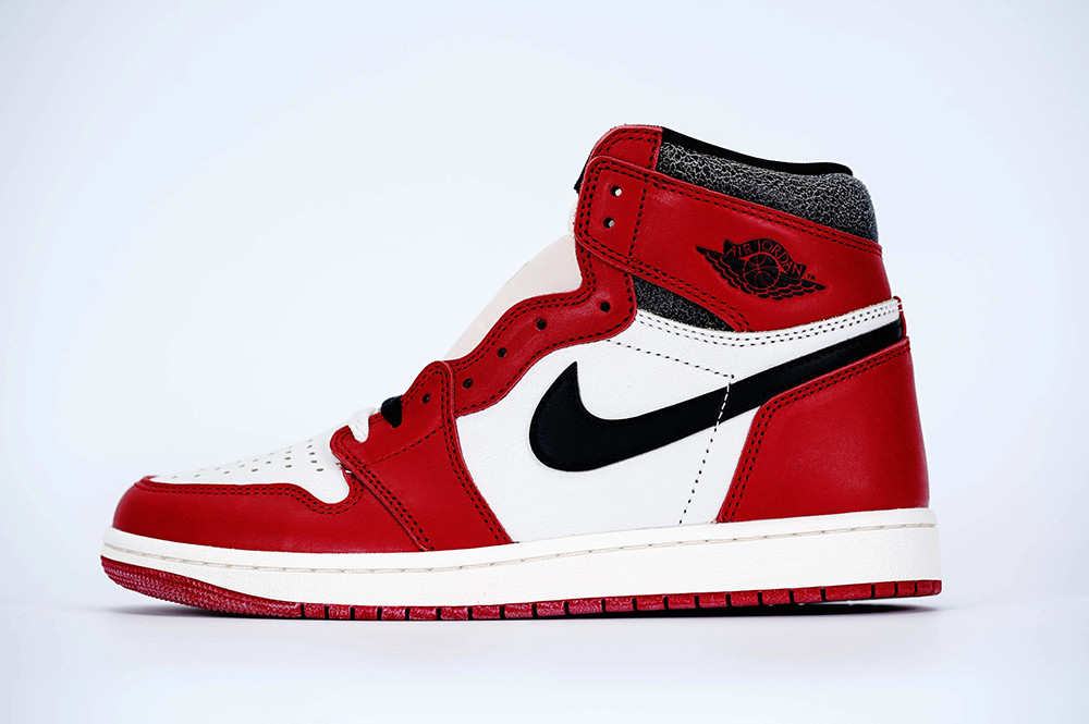 A side view of the left shoe of the Jordan 1 Chicago High OG ‘Lost & Found,’ highlighting its red, white, and black cracked leather materia
