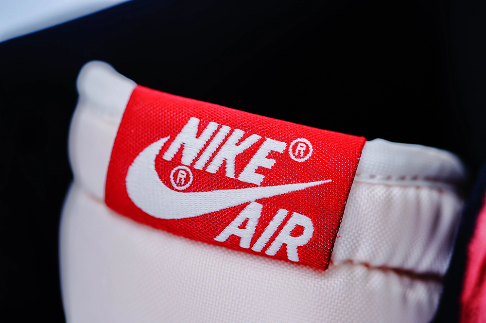 A top view of the woven tongue label on the Jordan 1 Chicago High OG ‘Lost & Found,’ highlighting its red and white polyester material