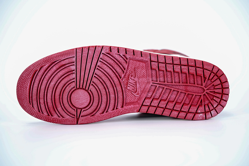 A bottom view of the Jordan 1 Chicago High OG ‘Lost & Found,’ showcasing the red outsole with a distressed white effect.