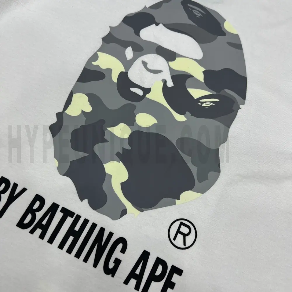 Detailed shot capturing the graphic print on the white tee's front panel.