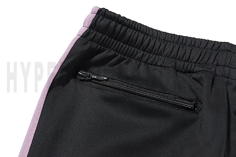 Detail of the back zip pocket on the track pants.