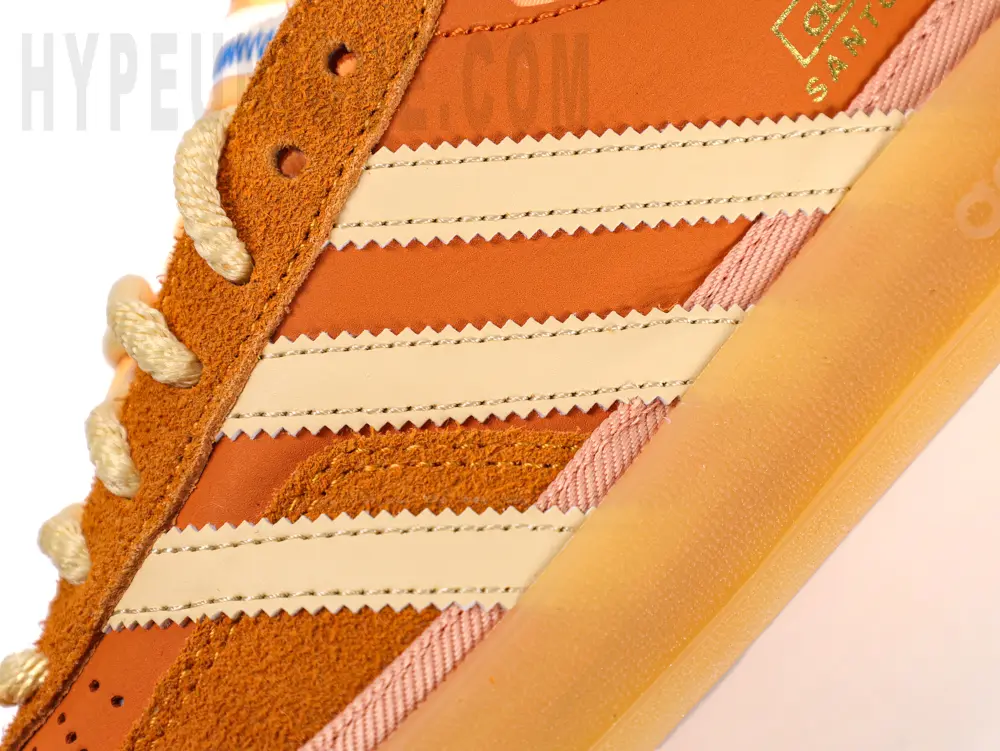 White adidas logo on the side and orange upper material