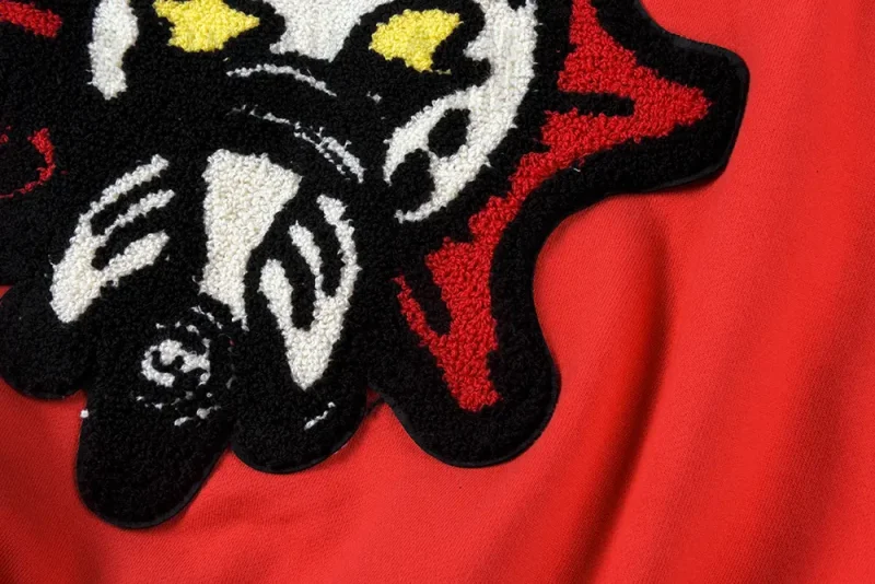 A close-up of the Almighty II Gang Full Zip Hoodie's back logo, showing the white and red fleece embroidery.