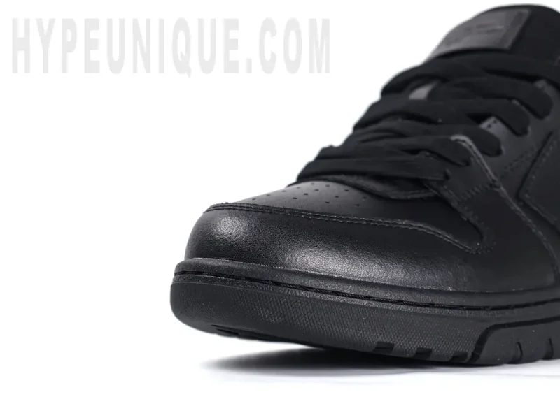 Close-up view of the black leather toe cap of the Off-White Out of Office Low 'Triple Black'.