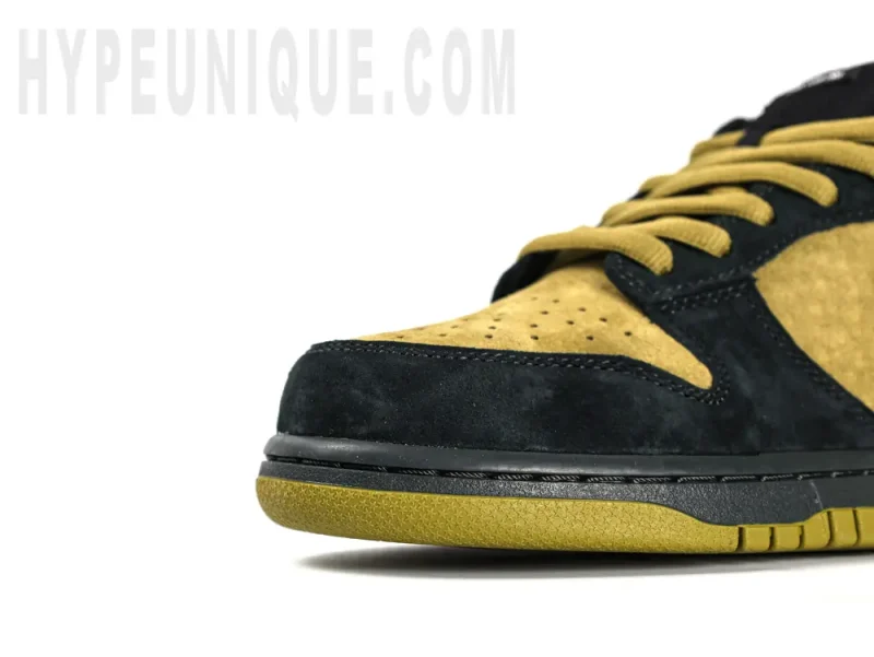 A close-up view of the Sup Dunk Low OG QS “Camper Green” with its black suede mudguard.