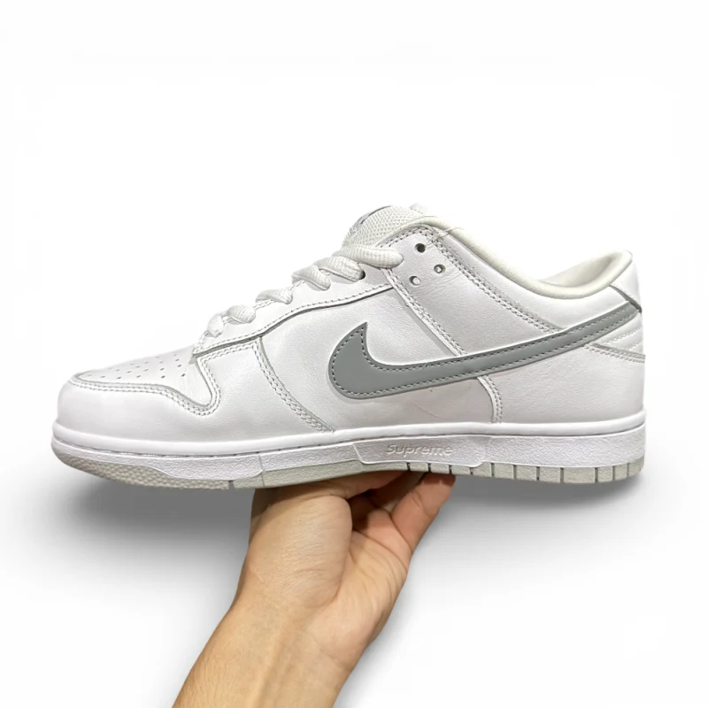 Side view of white low-top sneaker with metallic silver swoosh and clean leather upper