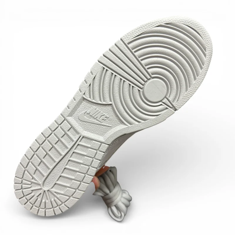 Bottom view of white rubber outsole with circular traction pattern and molded grooves