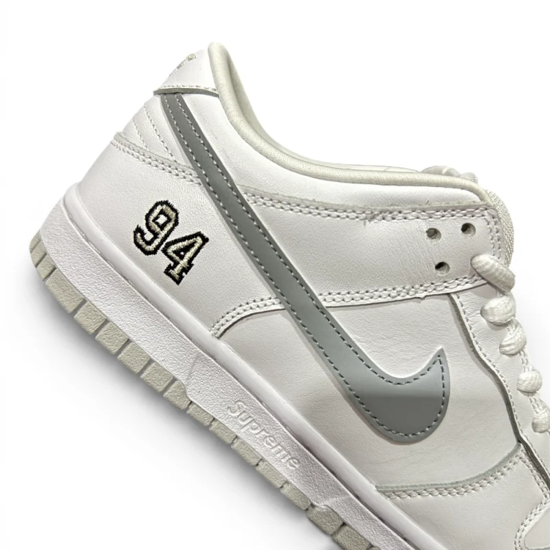 Side detail close-up showing embroidered number, metallic swoosh, and midsole branding