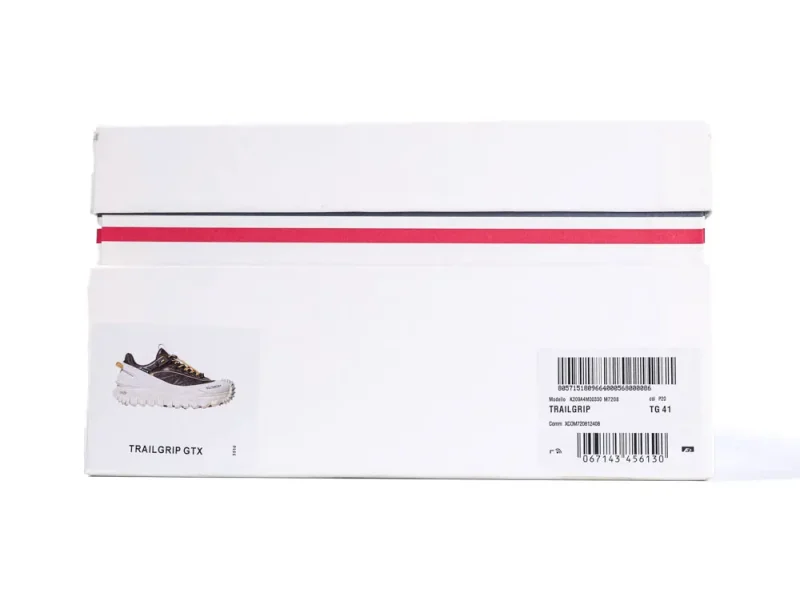 White shoebox with a red stripe, featuring a picture of a black and white Trailgrip GTX shoe on the side. Includes product details and barcodes on the label.
