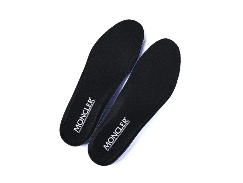 Two black shoe insoles with "MONCLER" branding in white text are placed diagonally against a white background.