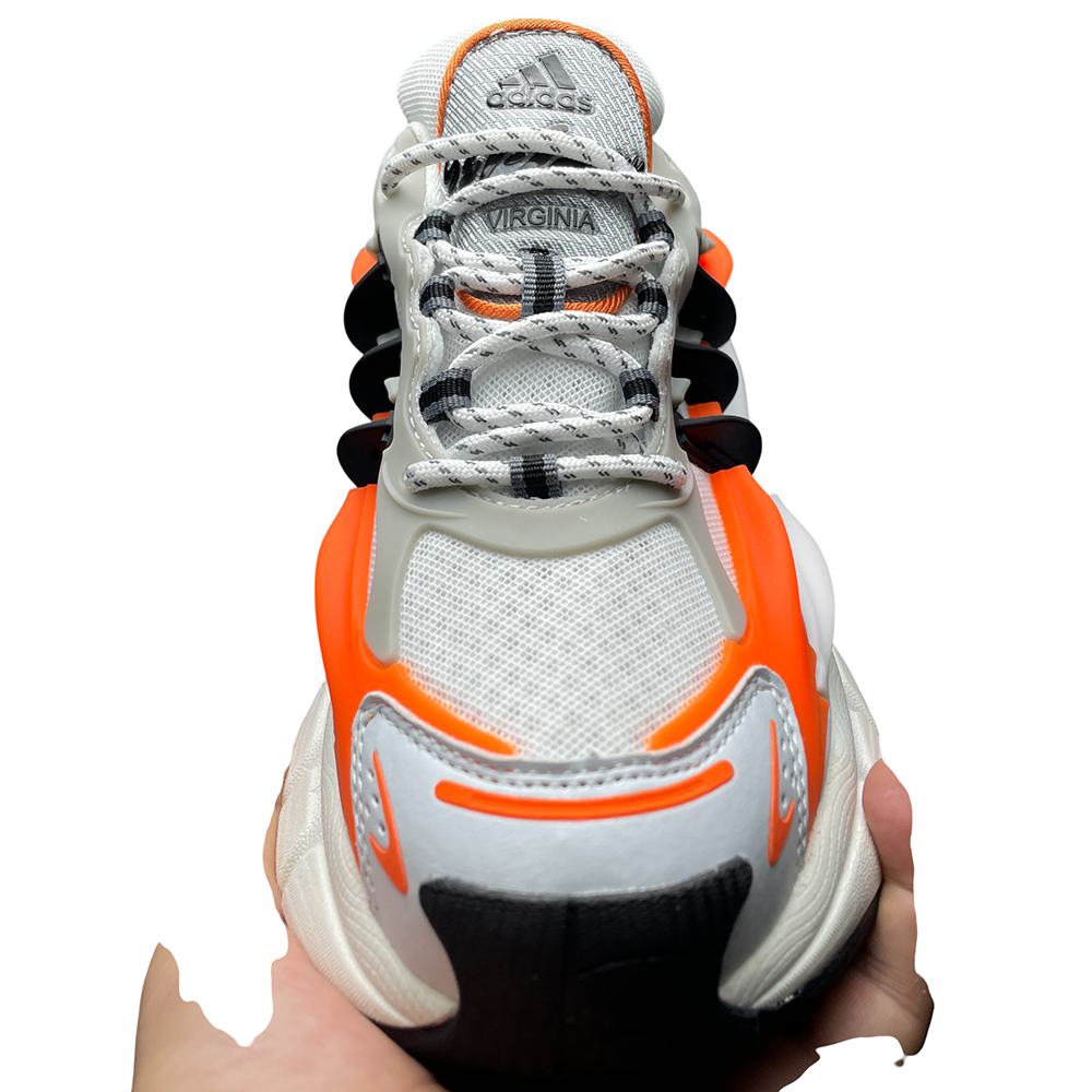 Close-up of a sneaker featuring white mesh fabric, vibrant orange accents, sleek gray overlays, and black detailing.