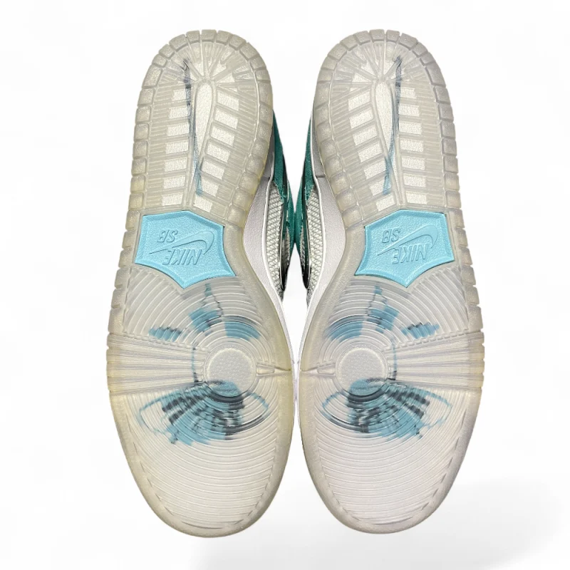 Turquoise suede and white mesh sneakers angled side-by-side, featuring a black logo, white laces, and grey soles.