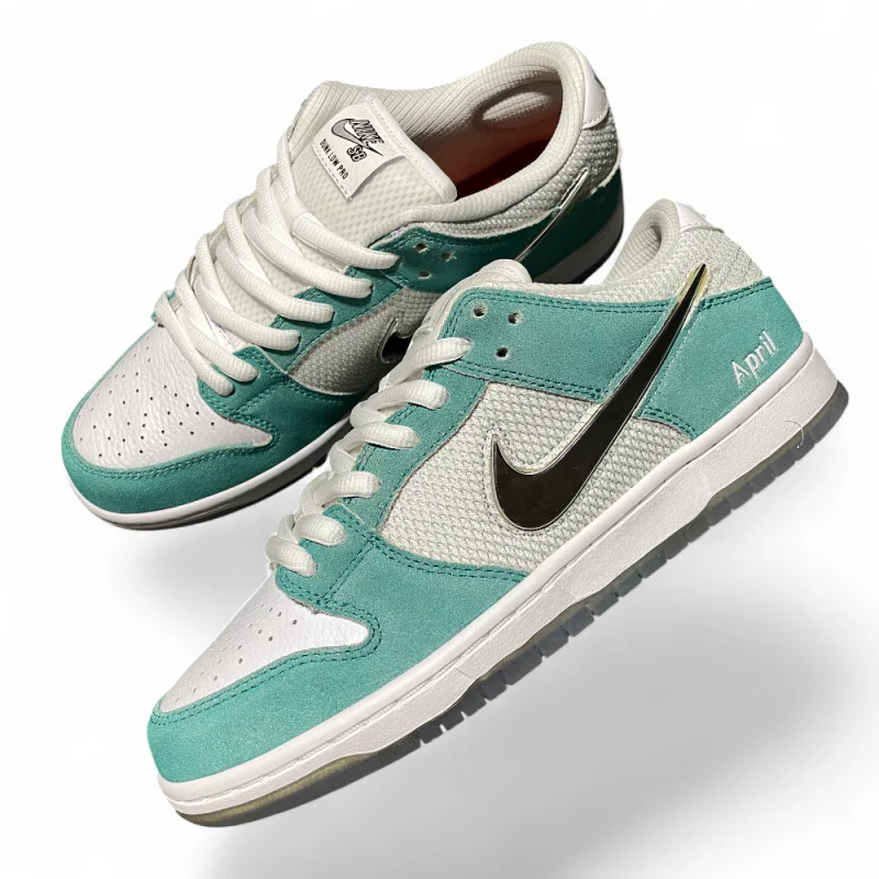 Turquoise suede and white mesh sneakers angled side-by-side, featuring a black logo, white laces, and grey soles.