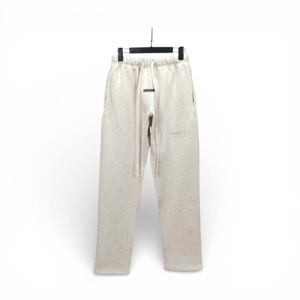 Beige cotton sweatpants with drawstring waist and side pockets, hanging on hanger.