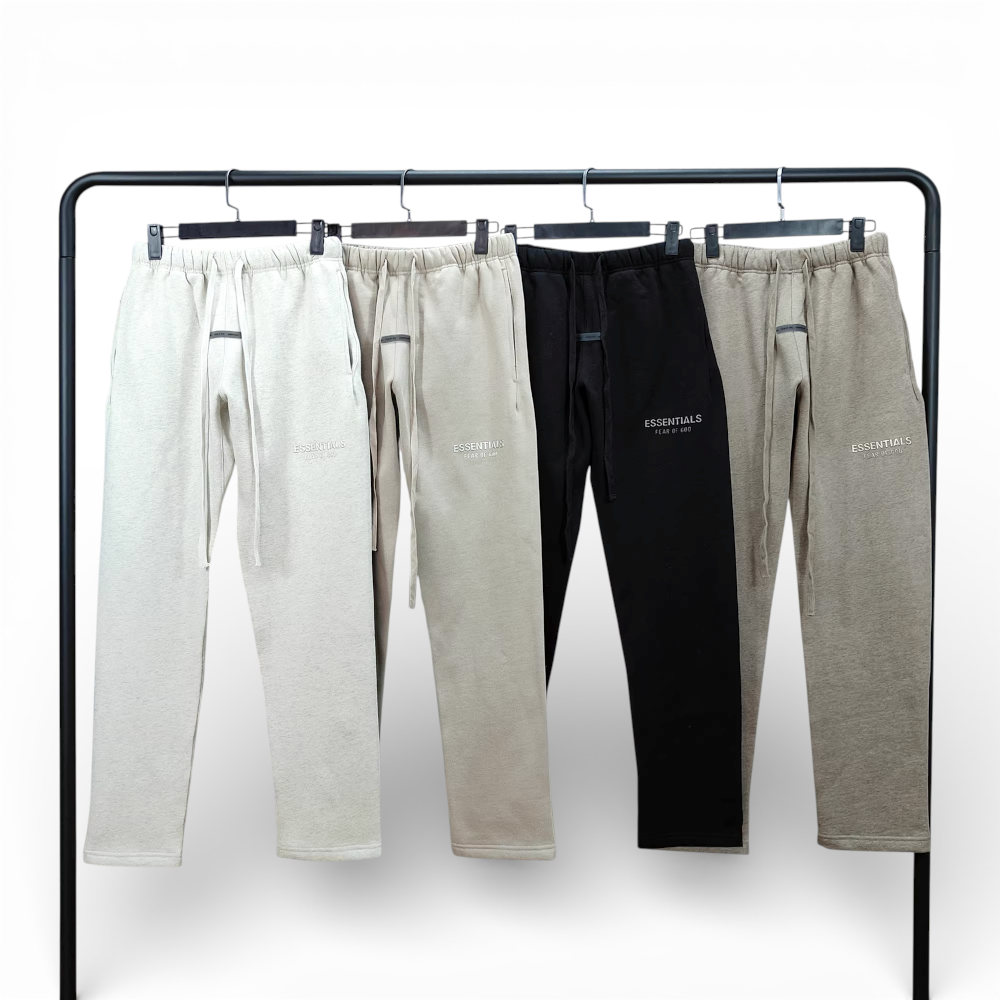 Four pairs of sweatpants in beige and black, cotton material, displayed on hangers.