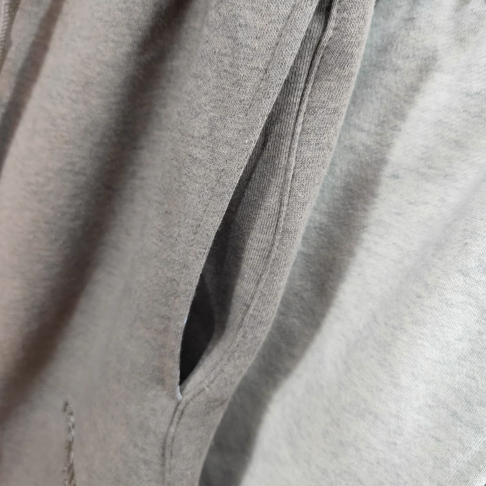 Gray fabric hoodie with a visible pocket, made of soft cotton material.