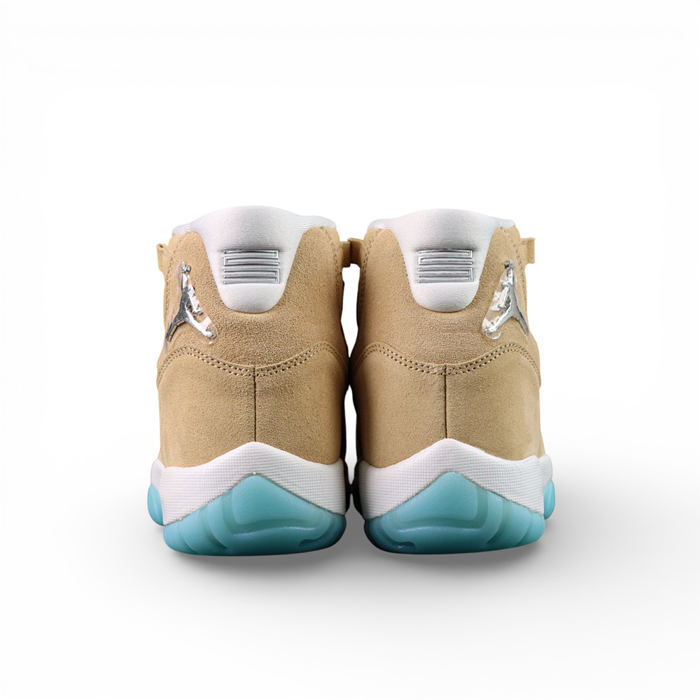 Beige suede sneakers with white laces and blue rubber soles.