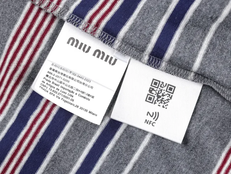 Gray fabric with red, white, blue stripes, labels featuring text, QR code, and NFC symbol; smooth and stitched textures.