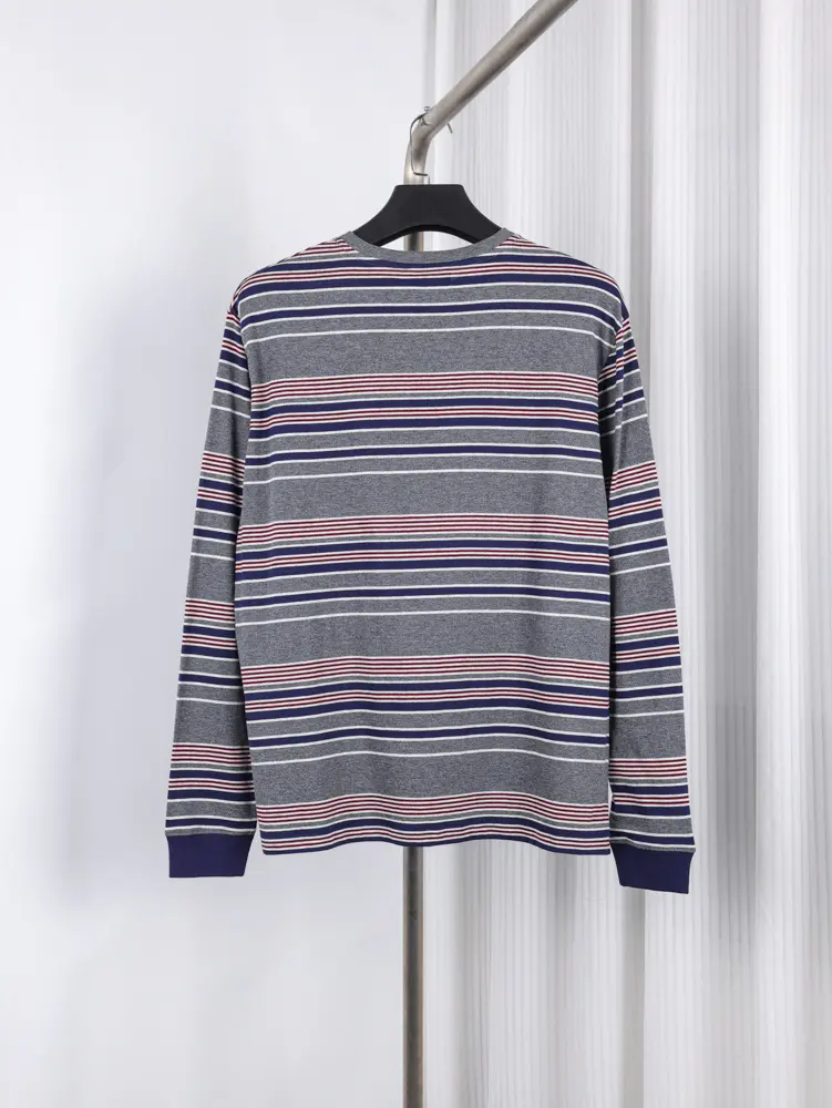Striped gray T-shirt with angled red and blue lines, sleek gray neckline, and visible tag showcasing modern design.
