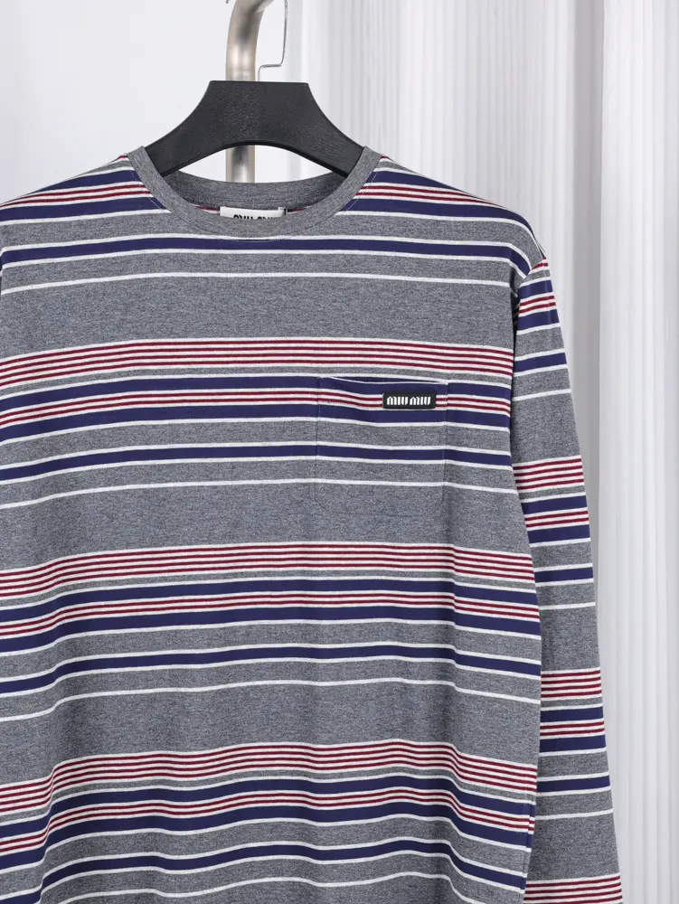 Striped fabric with red, white, and blue-gray colors, featuring navy cuffs. The texture appears soft and knitted.
