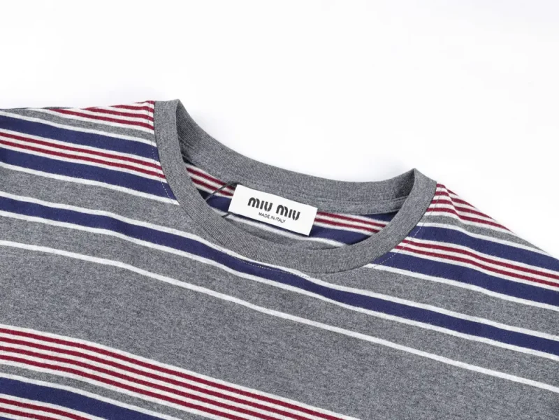 Striped gray T-shirt with angled red and blue lines, sleek gray neckline, and visible tag showcasing modern design.