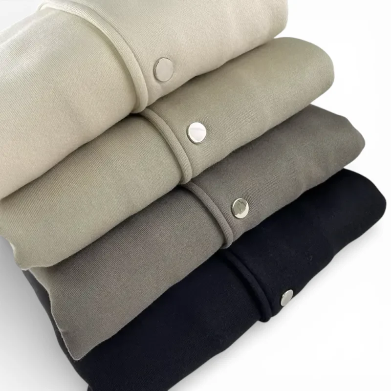 Four jackets of different colors are stacked on top of each other.