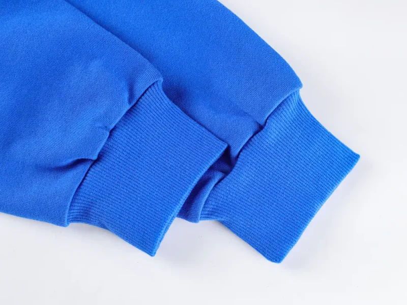 Blue cotton sweater sleeves with ribbed cuffs on a white background.