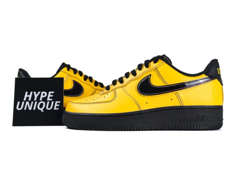 Yellow leather sneakers with black accents and rubber sole, displayed on white background.