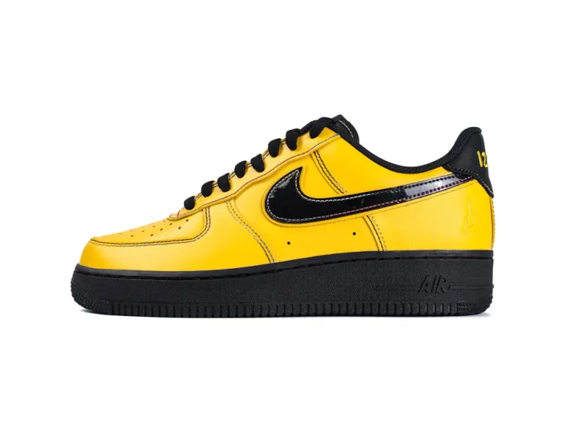 Yellow leather sneaker with black accents, featuring a prominent logo and textured sole.