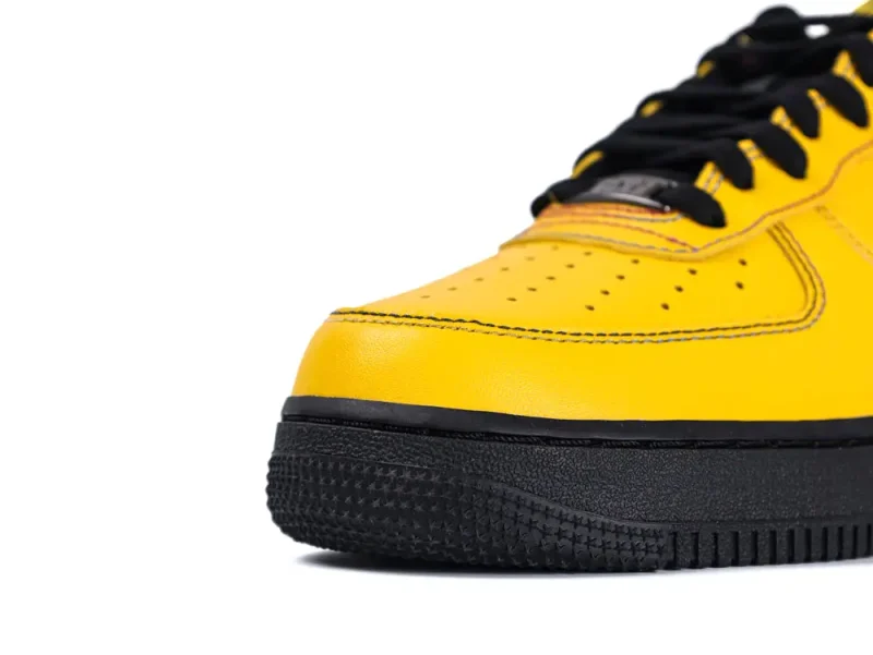 Yellow leather sneaker with black rubber sole and black laces, close-up view.