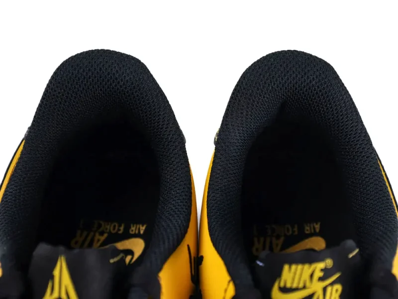 Black and yellow mesh sneakers' interior view, showcasing comfortable cushioning and design.