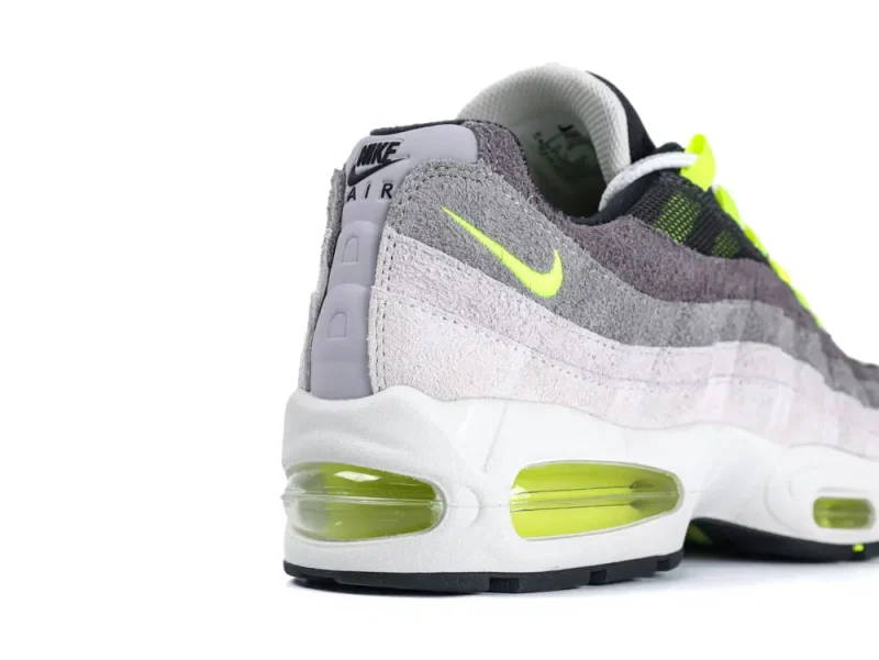 Gray suede sneaker with neon accents, featuring a white midsole and transparent air cushion.