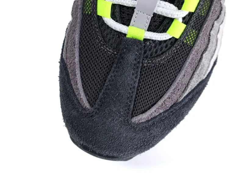Black and gray suede and mesh sneaker toe with neon yellow accents.