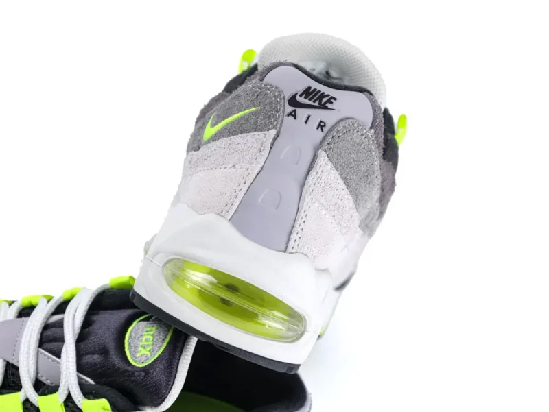 Gray and neon green sneaker with suede upper and visible air cushion.