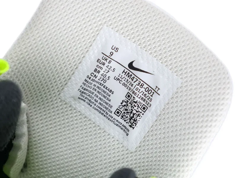 White mesh fabric with a clothing tag featuring size and manufacturing details.