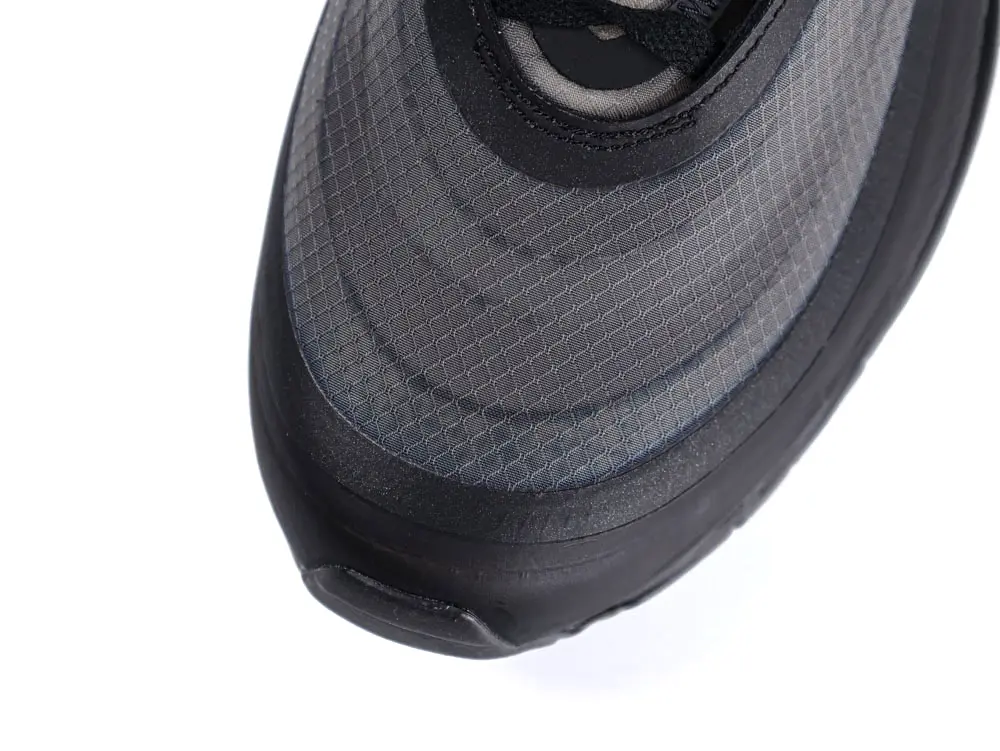Close-up of a gray mesh sneaker toe with black rubber trim.