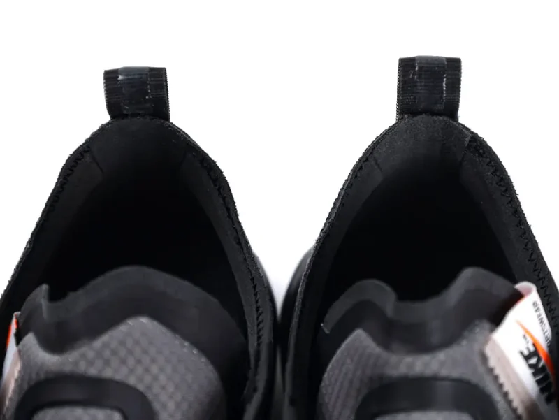 Top view of black and gray fabric sneakers showcasing inner sides and pull tabs.