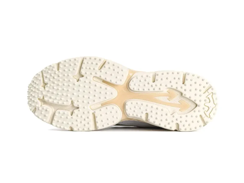 Beige and cream rubber shoe sole with textured grip and arrow pattern.