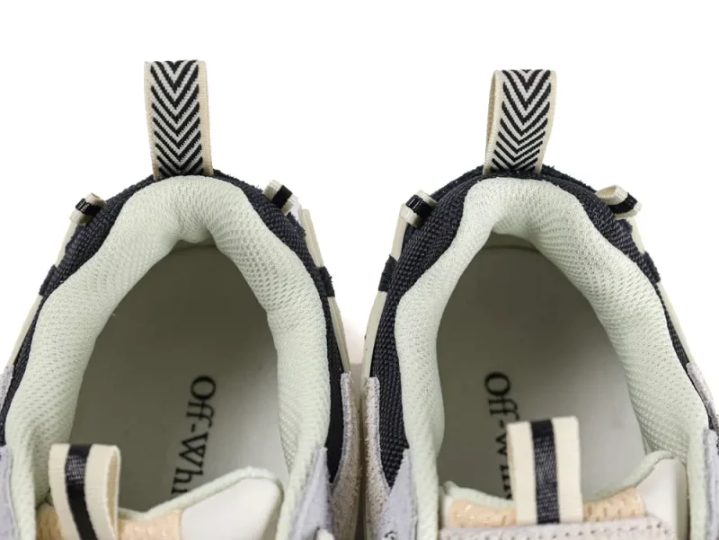 Gray and beige sneakers with black striped pull tabs and cushioned inner lining.