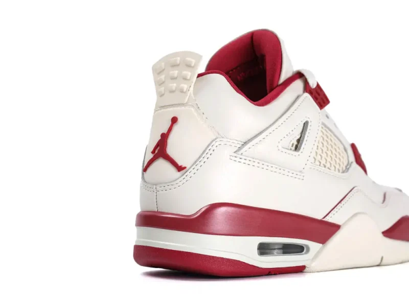 Cream and red leather sneaker with mesh detailing and rubber sole, side view.