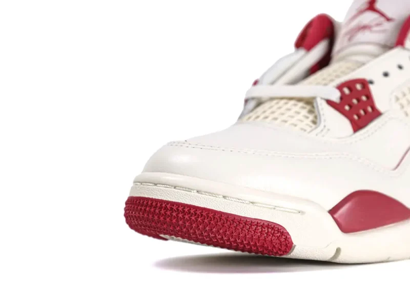 White and red sneaker with leather upper and rubber toe detailing.
