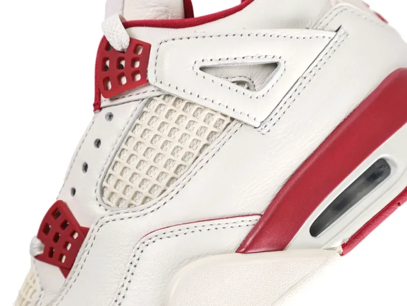 White and red leather sneaker with mesh detailing and cushioned sole.