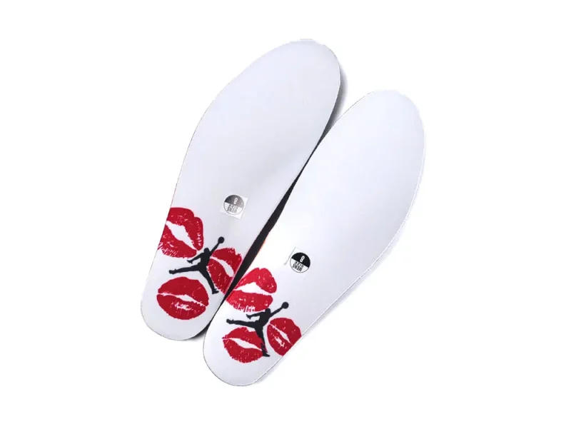 White shoe insoles with red lips design and Jumpman logo, fabric material.