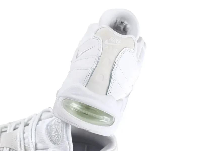White sneaker with fabric upper and clear rubber air-cushioned sole section.