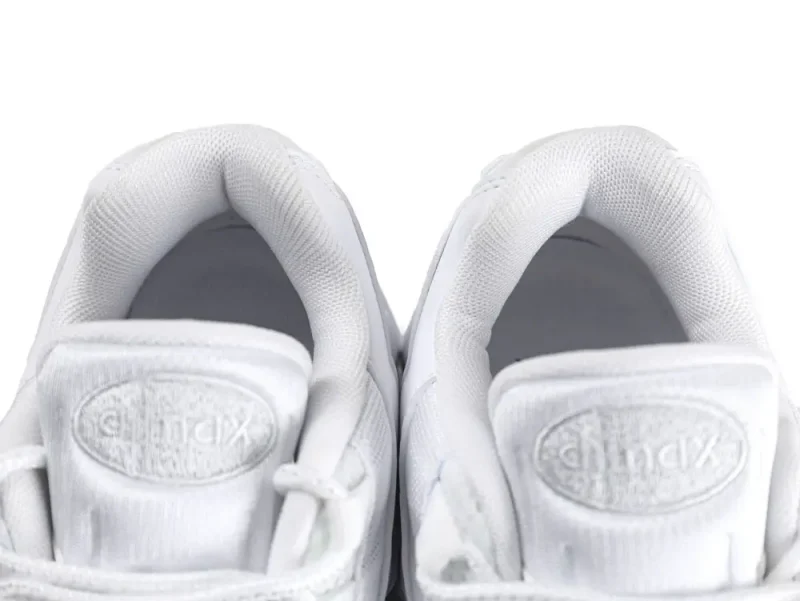 White sneaker with fabric upper and clear rubber air-cushioned sole section.