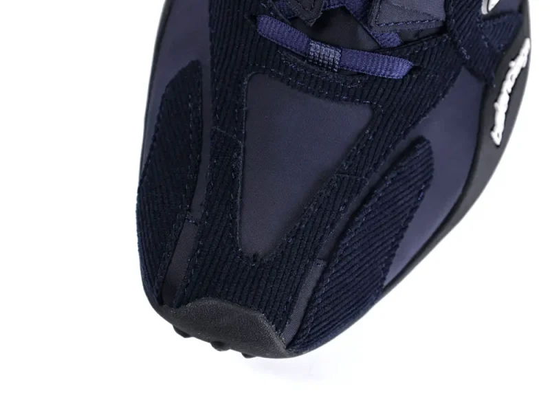 Navy blue sneaker with a mesh and suede upper, featuring a rubber sole.