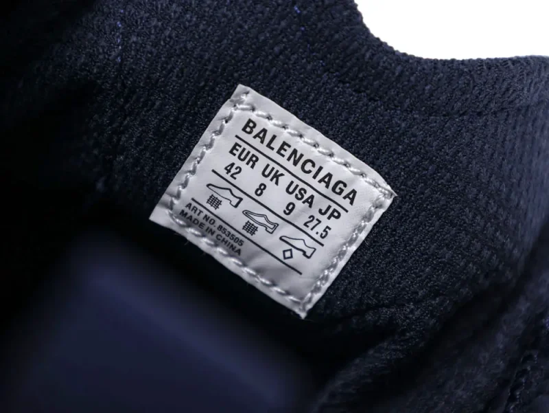 White fabric label on dark textured material with size details and brand name.